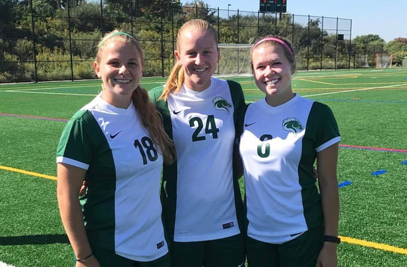 Three women in soccer jerseys.